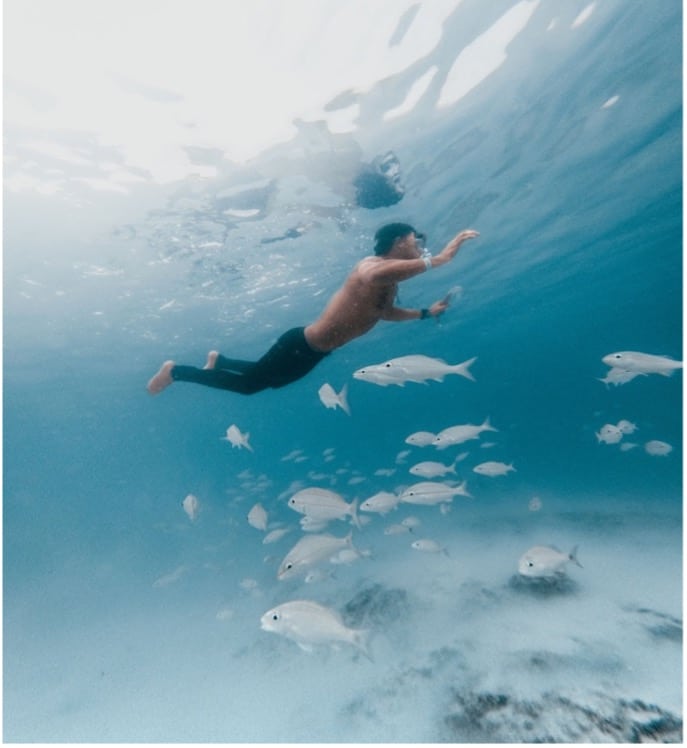 picture of a man swimming underwater with some fish